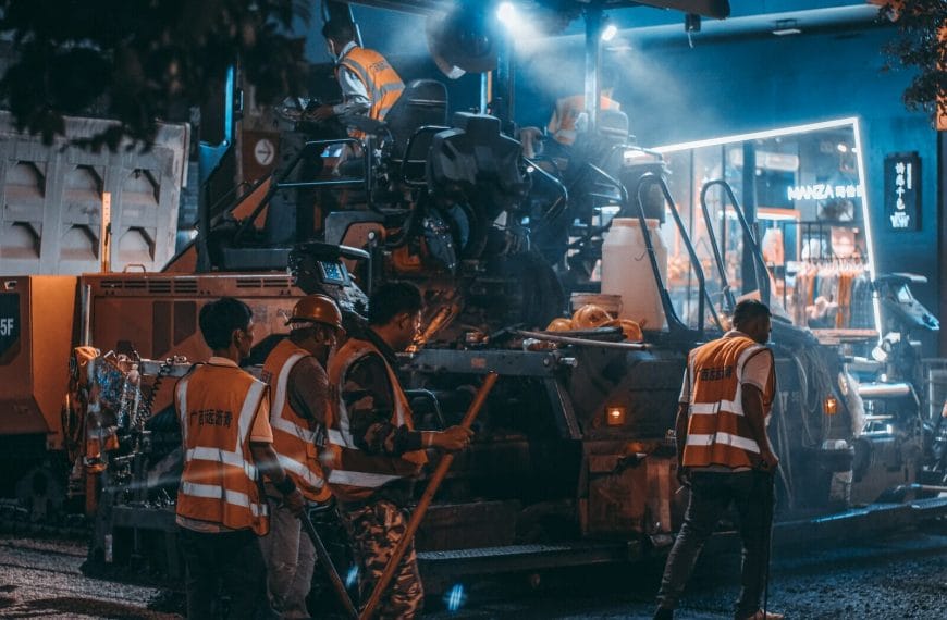 Workers Using Heavy Machine in Asphalt Laying