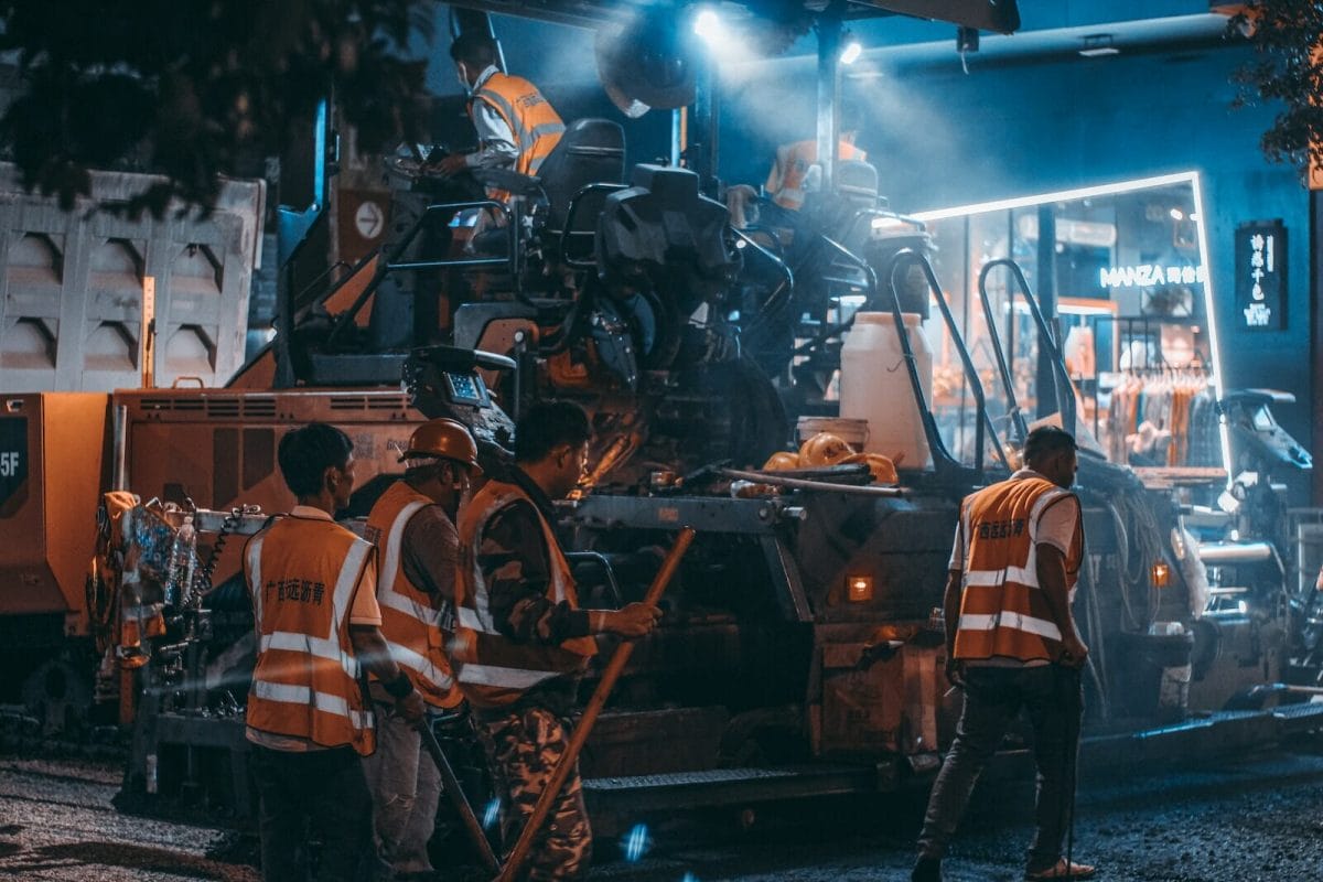 Workers Using Heavy Machine in Asphalt Laying